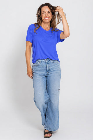 Classic Bamboo T-Shirt in Cobalt Blue, full length front view on model with hand in hair, styled with wide leg jeans.