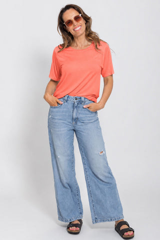 Classic Bamboo T-Shirt in Coral, full length front view on model wearing sunglasses, styled with wide leg jeans and sandals.