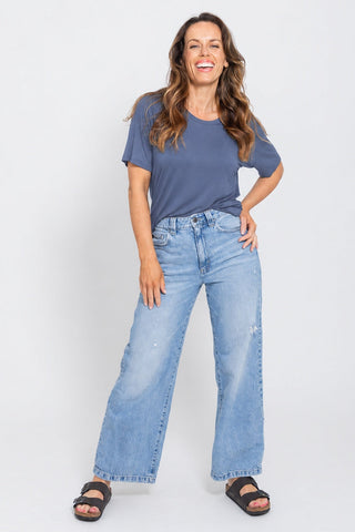 Classic Bamboo T-Shirt in Denim Blue, full length front view on model with hand on hip, styled with wide leg jeans and sandals.