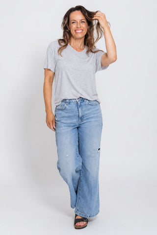 Classic Bamboo T-Shirt in Grey Marle, full length front view on model with hand in hair, styled with wide leg jeans.