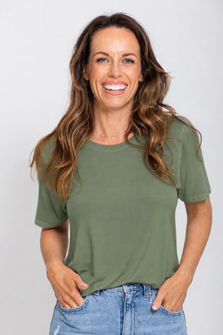 Classic Bamboo T-Shirt in Moss, close up front view on model smiling with hands in pockets, styled with denim jeans.