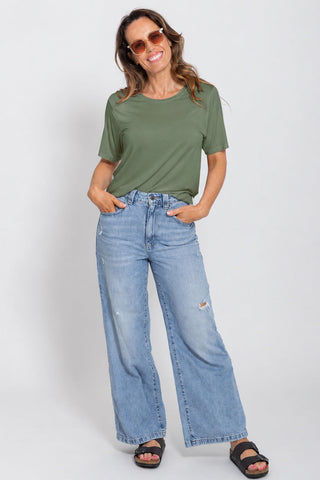 Classic Bamboo T-Shirt in Moss, full length front view on model wearing sunglasses, styled with wide leg jeans and sandals.