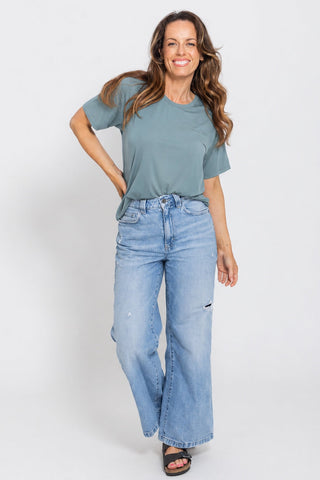Classic Bamboo T-Shirt in Sage, full length front view on model with hand on hip, styled with wide leg jeans.