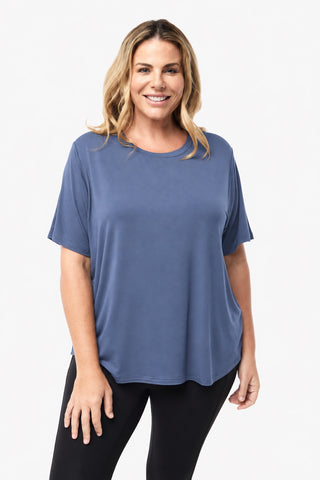Classic Bamboo T-Shirt in Denim Blue, front view on model smiling, styled with black leggings.
