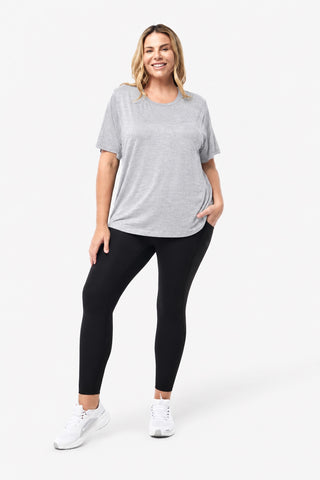 Classic Bamboo T-Shirt in Grey Marle, full length front view on model with hands in pockets, styled with black leggings and white sneakers.