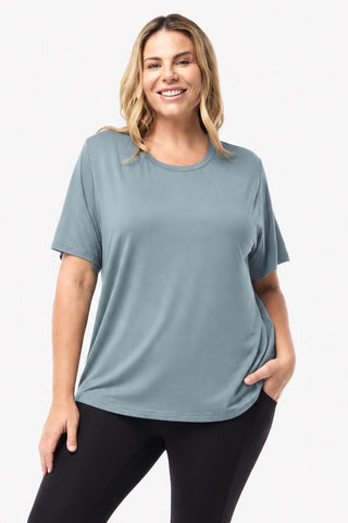 Classic Bamboo T-Shirt in Sage, front view on model with hand in pocket, styled with black leggings.