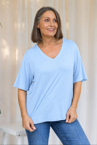 Bamboo V-Neck T-Shirt in Sky Blue, front view on model smiling, styled with denim jeans.