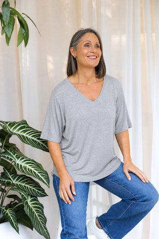 Bamboo V-Neck T-Shirt in Grey Marle, front view on model seated on a stool, styled with denim jeans.