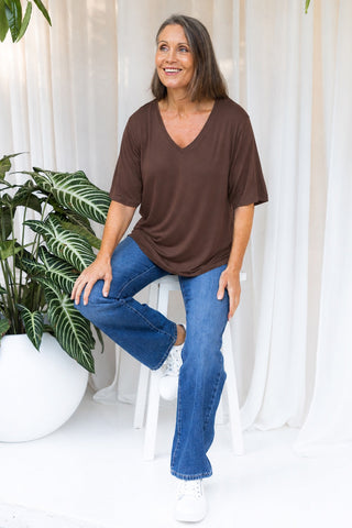 Bamboo V-Neck T-Shirt in Mocha, full length view on model seated on a stool, styled with denim jeans.