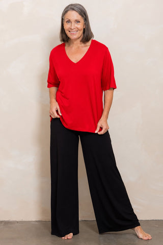 Bamboo V-Neck T-Shirt in Red, full length front view on model, styled with black wide leg pants.