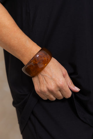 Chunky Resin Bangle in Tortoiseshell, close up worn on a model's wrist.