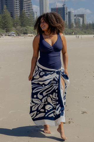 Burleigh Core Support One Piece Swim in Navy Texture, front view on model styled with a matching sarong on the beach
