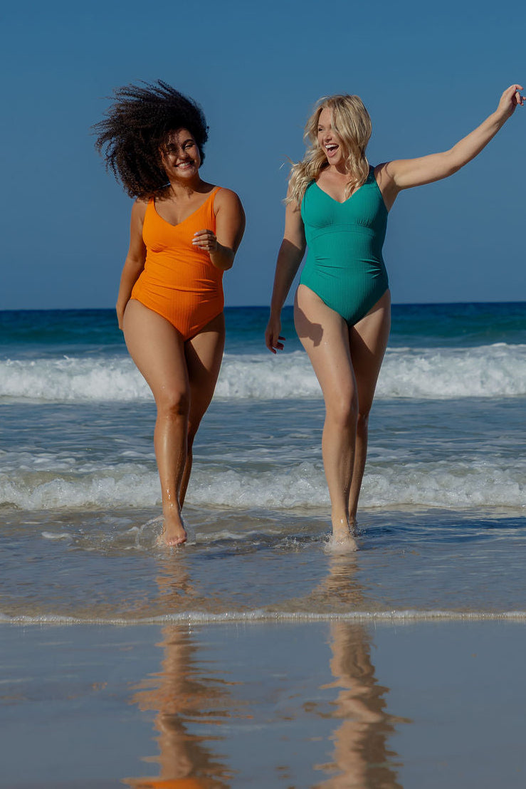 Coolum Core Support One Piece Swim in Emerald Texture, full body view of two models with arms raised at the beach.