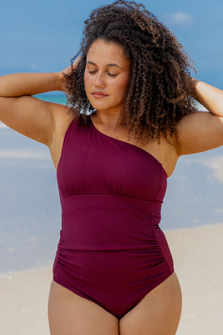 Esperance Core Support One Piece Swim in Dark Cherry Texture, front view on model showing the one shoulder neckline