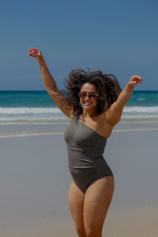 Esperance Core Support One Piece Swim in Khaki Texture, front view on model with arms raised at the beach