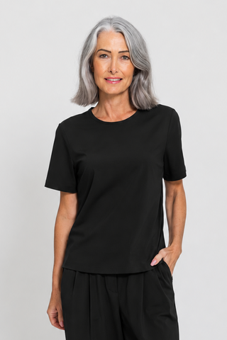 Motion Tee in Black, front view on model styled with tapered pants.