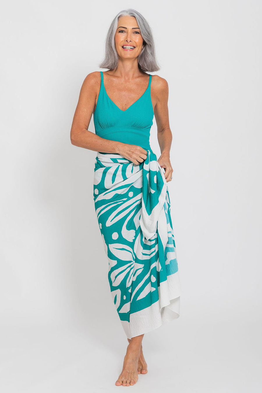 Coolum Core Support One Piece Swim in Emerald Texture, full body view on model standing in studio, styled with a printed wrap skirt. Model: Model wears a size S. She is size 10 and 178cm tall.