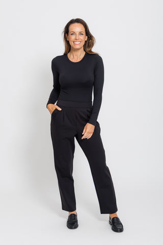 Sculpt Crew Neck Bodysuit in Black, full length front view walking, styled with black trousers and heels.