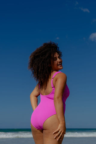 Sorrento Core Support One Piece Swim in Hot Pink Texture, back view on model looking over her shoulder