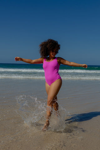 Sorrento Core Support One Piece Swim in Hot Pink Texture, front view on model splashing in the surf