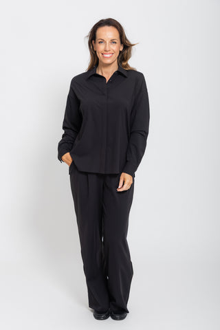 Motion Shirt in Black, full body front view on model styled with wide leg pants.